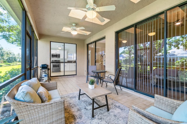 sunroom with a skylight, a healthy amount of sunlight, and ceiling fan