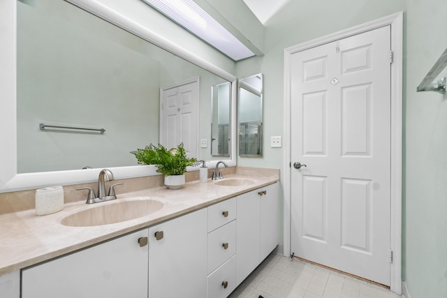 bathroom with double vanity, a sink, and tile patterned floors