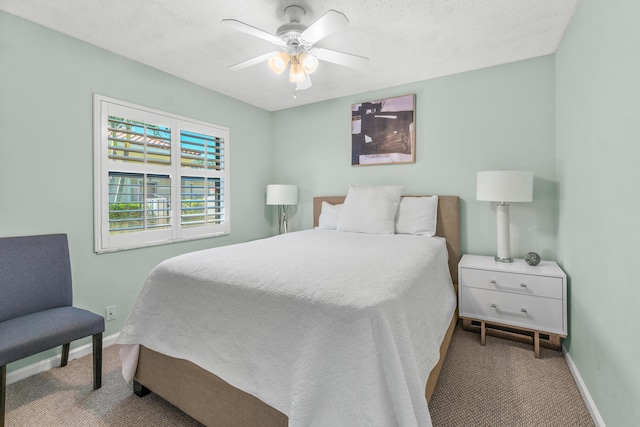 bedroom with carpet, a textured ceiling, baseboards, and a ceiling fan