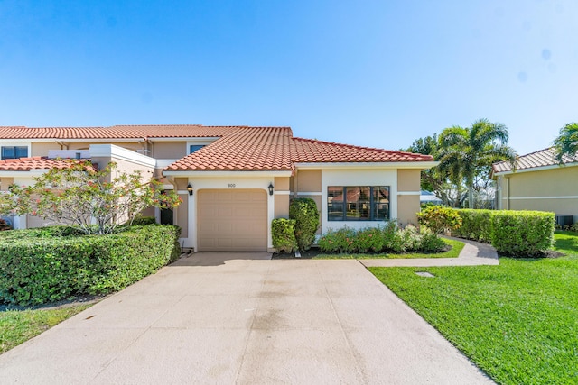 mediterranean / spanish-style house with an attached garage, a tile roof, concrete driveway, stucco siding, and a front lawn