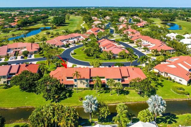 drone / aerial view featuring a water view, view of golf course, and a residential view