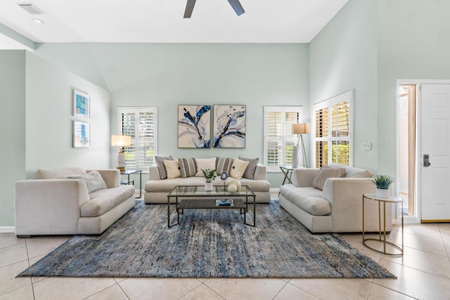 living room featuring tile patterned flooring, visible vents, high vaulted ceiling, and a ceiling fan