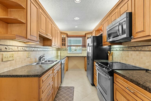 kitchen featuring dark countertops, appliances with stainless steel finishes, open shelves, a sink, and light tile patterned flooring