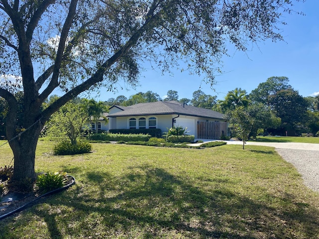 view of front of house with an attached garage, driveway, and a front yard