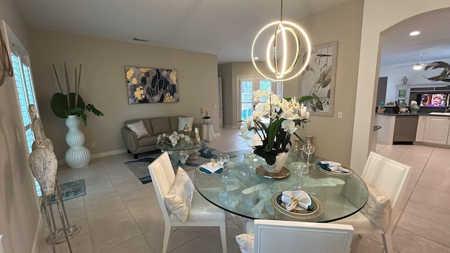 dining area featuring arched walkways, light tile patterned floors, recessed lighting, baseboards, and ceiling fan with notable chandelier