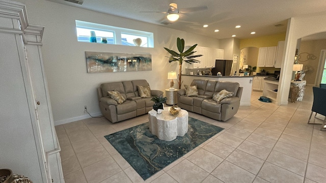 living area featuring arched walkways, light tile patterned floors, recessed lighting, visible vents, and a ceiling fan