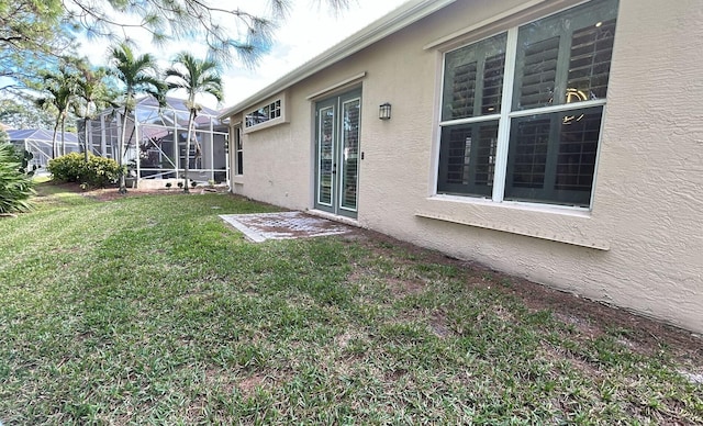 view of yard with glass enclosure and french doors