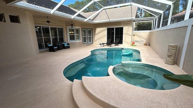 view of pool featuring a pool with connected hot tub, a patio area, ceiling fan, and a lanai