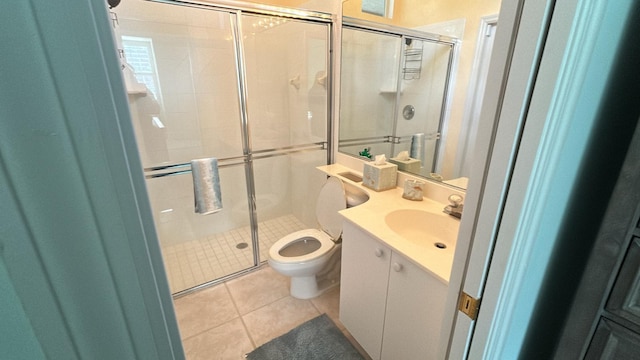 bathroom with toilet, a shower stall, vanity, and tile patterned floors