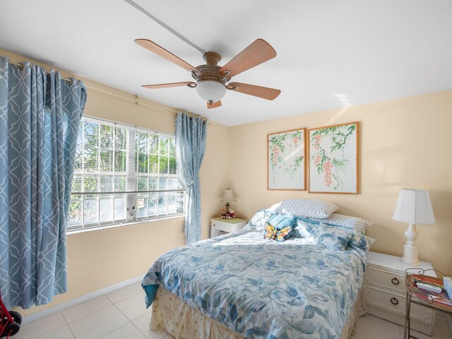 bedroom with ceiling fan, baseboards, and light tile patterned flooring