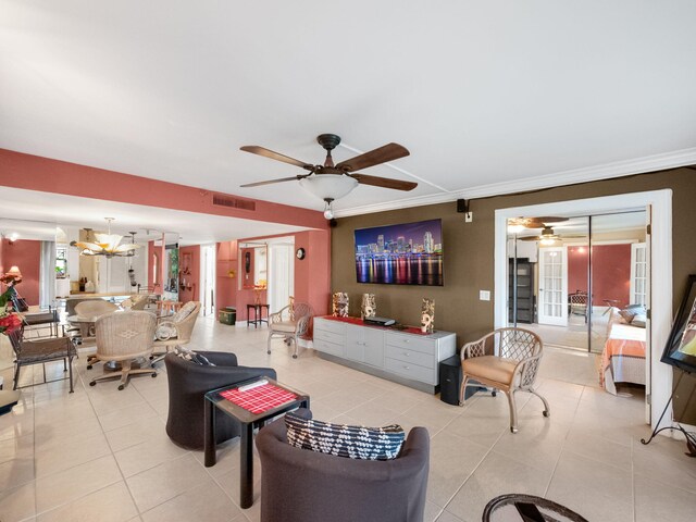 living area featuring ceiling fan with notable chandelier, visible vents, ornamental molding, and light tile patterned flooring