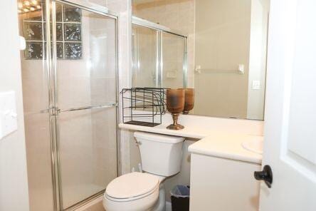 full bath with a stall shower, vanity, and toilet