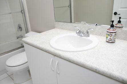 full bath featuring toilet, tile patterned floors, combined bath / shower with glass door, and vanity