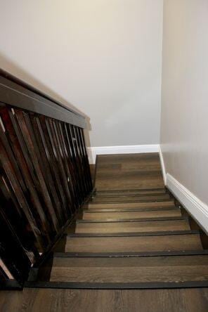 stairway with baseboards and wood finished floors