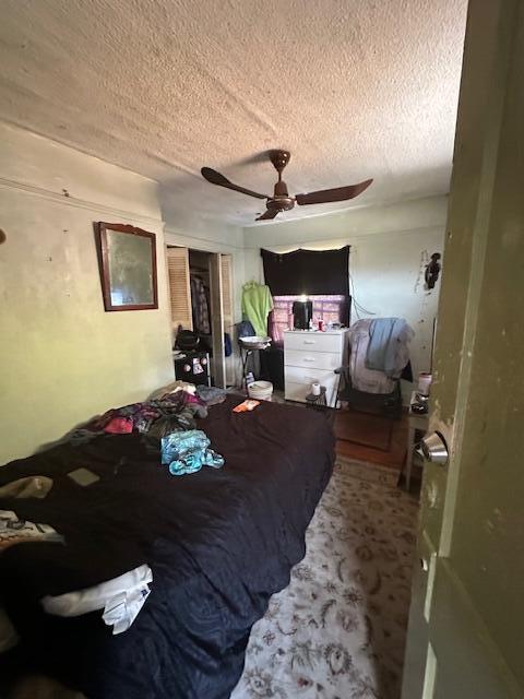 bedroom featuring a textured ceiling, a closet, and a ceiling fan