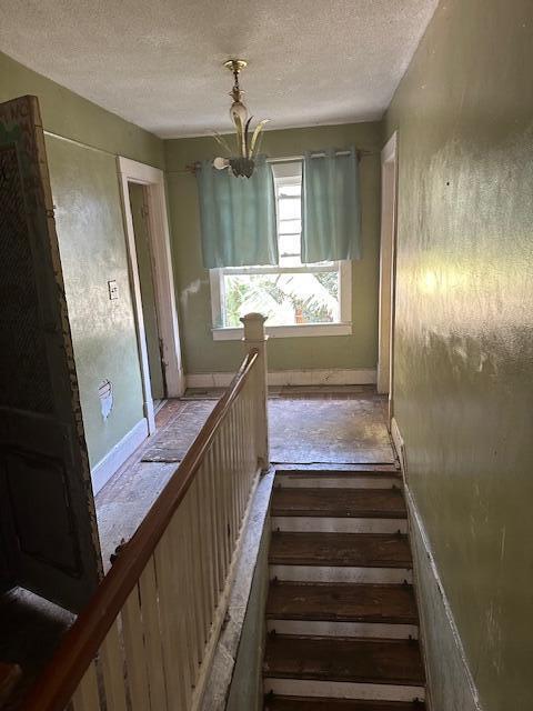 staircase with a textured ceiling