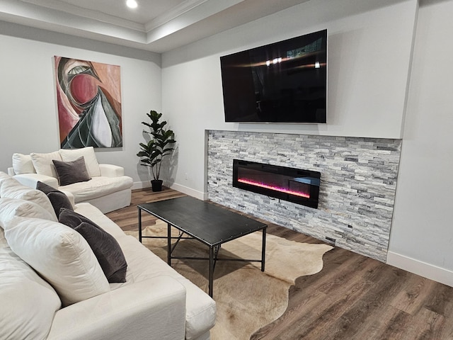 living area featuring recessed lighting, a stone fireplace, baseboards, and wood finished floors