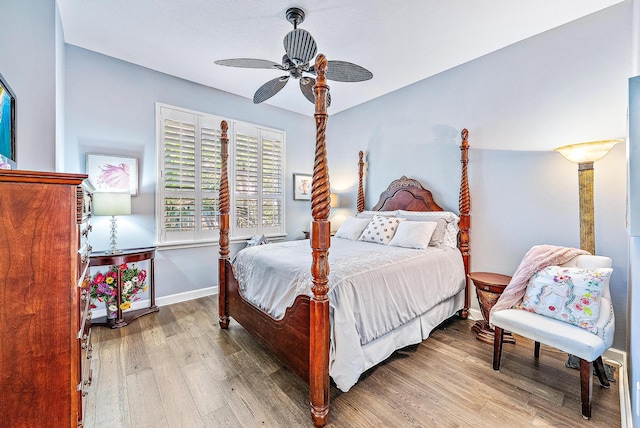 bedroom with wood finished floors, a ceiling fan, and baseboards