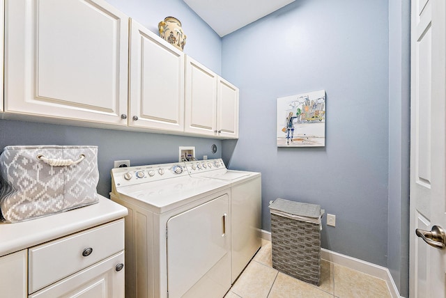 laundry room featuring light tile patterned floors, independent washer and dryer, cabinet space, and baseboards