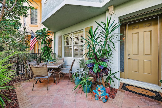 property entrance with outdoor dining space, a patio area, and stucco siding