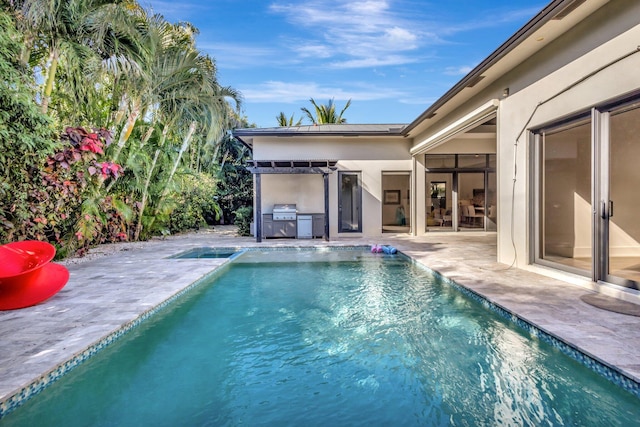 outdoor pool with a patio area and area for grilling