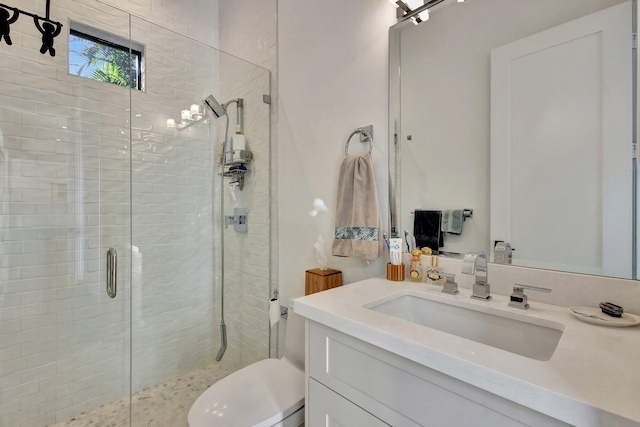 full bathroom with vanity, a shower stall, and toilet