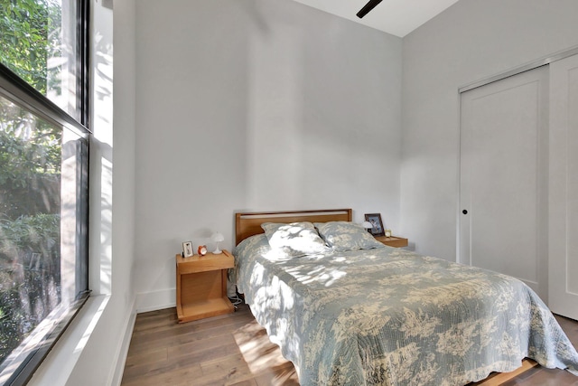 bedroom featuring a closet, baseboards, and wood finished floors