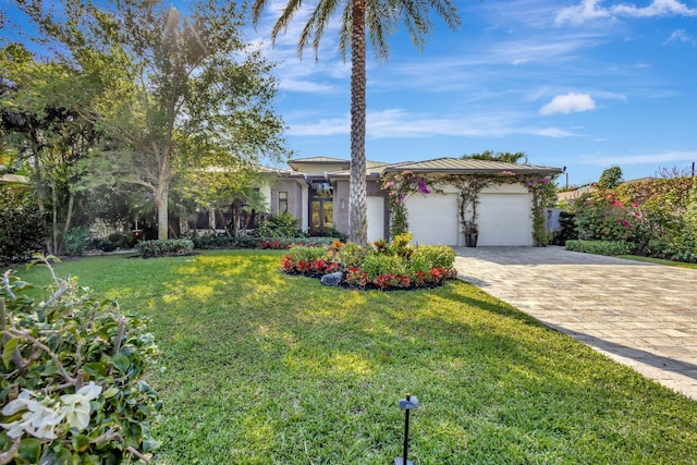 view of front of property featuring a garage, decorative driveway, and a front lawn