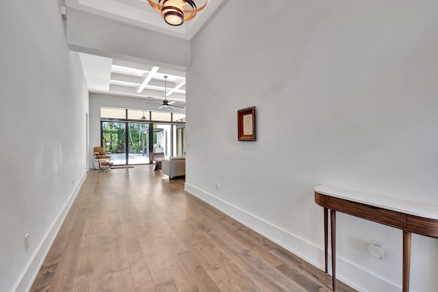 hall with coffered ceiling, wood finished floors, beam ceiling, and baseboards