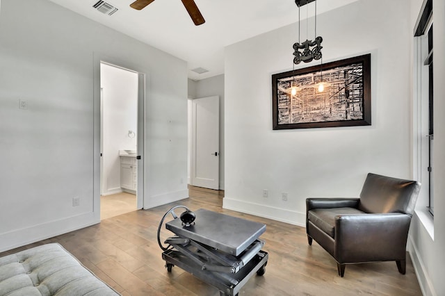 sitting room featuring a ceiling fan, baseboards, visible vents, and wood finished floors