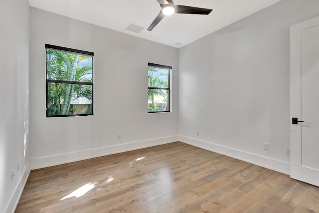 spare room with ceiling fan, hardwood / wood-style flooring, and baseboards