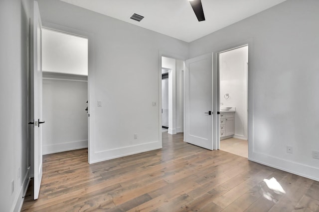 unfurnished bedroom featuring a closet, visible vents, baseboards, and light wood finished floors