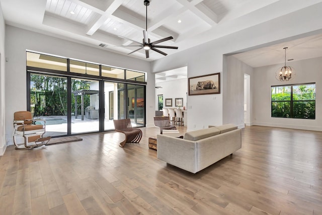 living area with a healthy amount of sunlight, a high ceiling, and wood finished floors