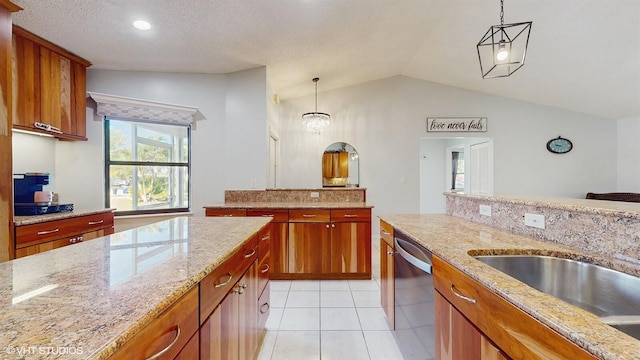 kitchen with dishwasher, vaulted ceiling, brown cabinetry, hanging light fixtures, and light tile patterned flooring