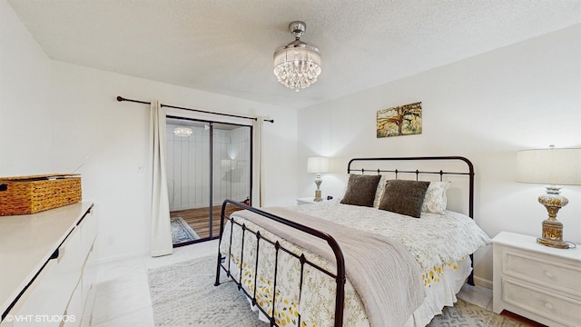 bedroom with a chandelier, access to outside, light tile patterned floors, and baseboards