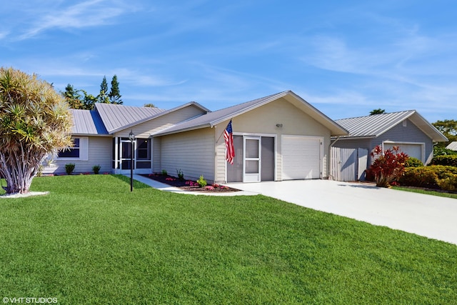 ranch-style house with a garage, concrete driveway, metal roof, and a front lawn