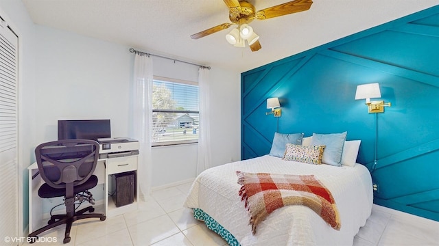 tiled bedroom with ceiling fan and baseboards