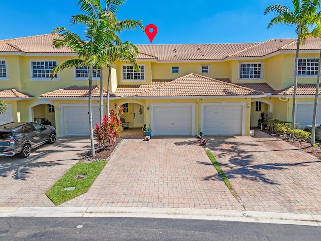 view of front of home with a garage, driveway, and stucco siding