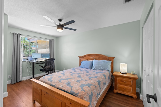 bedroom featuring a textured ceiling, wood finished floors, a ceiling fan, and baseboards