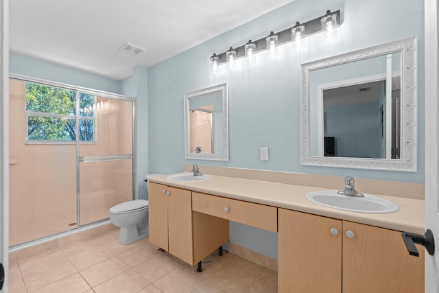 bathroom with toilet, a sink, visible vents, and a shower stall