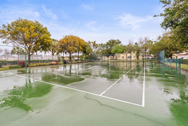 exterior space featuring a tennis court and fence