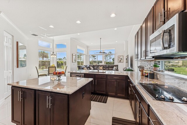 kitchen featuring decorative backsplash, a center island, a peninsula, stainless steel appliances, and a sink