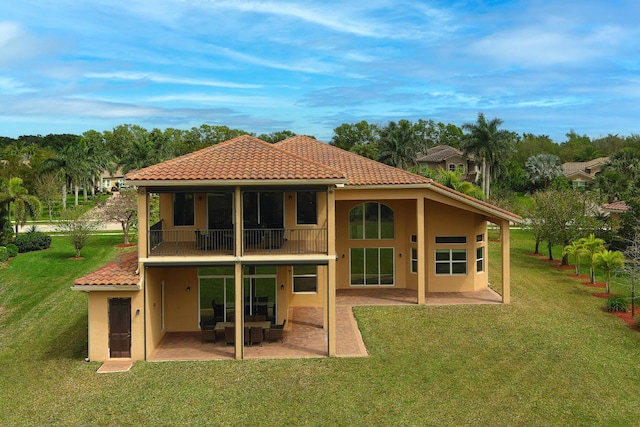 back of property featuring stucco siding, a lawn, and a patio