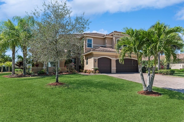 mediterranean / spanish house with decorative driveway, a tile roof, stucco siding, an attached garage, and a front yard