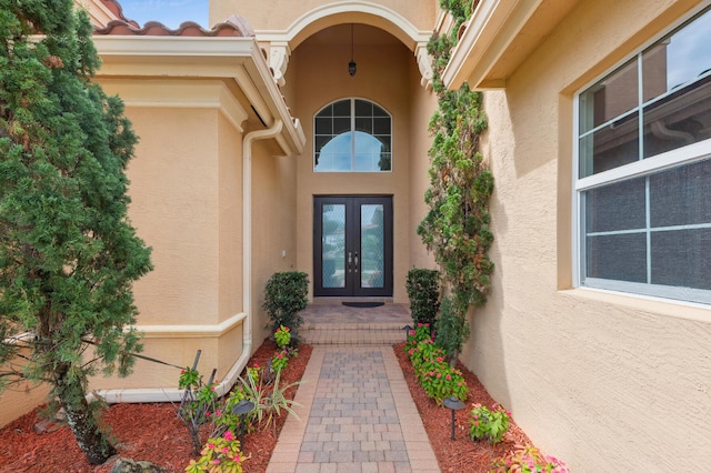 doorway to property with french doors, a tile roof, and stucco siding