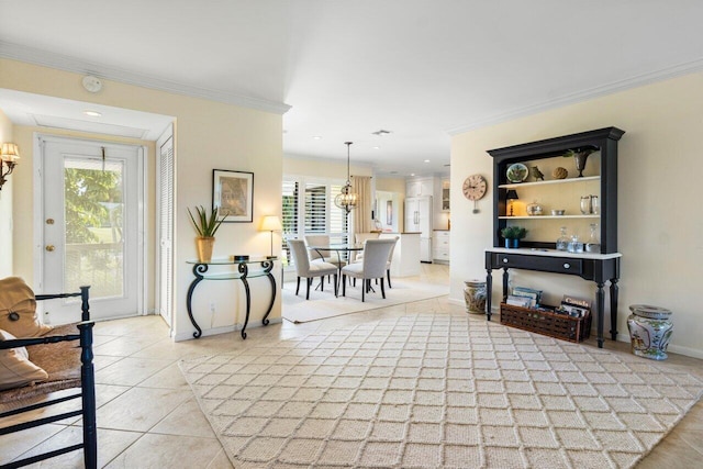 entrance foyer with light tile patterned floors, baseboards, ornamental molding, and a chandelier