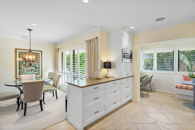 kitchen with a chandelier, decorative light fixtures, crown molding, white cabinetry, and recessed lighting