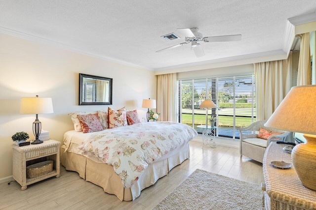 bedroom with ornamental molding, visible vents, and a textured ceiling