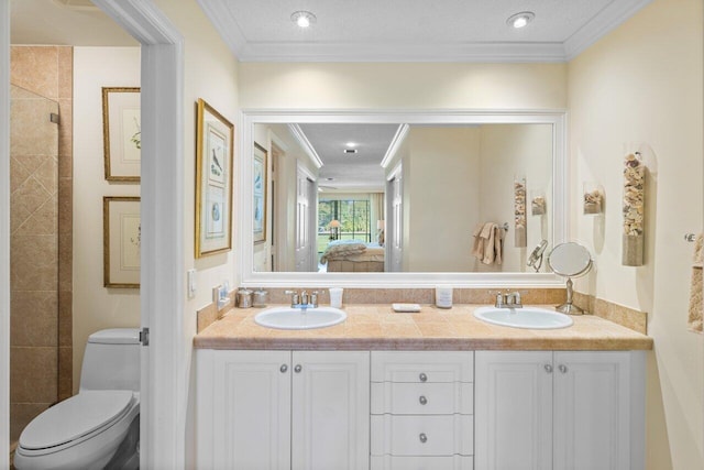 full bath featuring toilet, connected bathroom, ornamental molding, and a sink