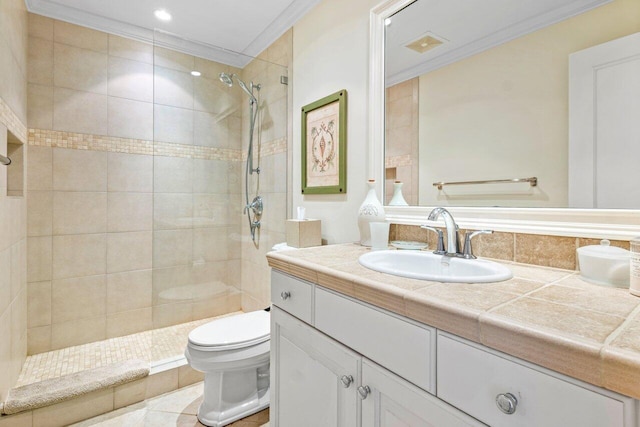 bathroom featuring visible vents, tiled shower, toilet, crown molding, and vanity